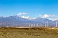 Aug 2017 Ã¢â¬â Xinjiang, China Ã¢â¬â A Wind farm near Urumqi, with the majestic height of Tianshan behind it. Royalty Free Stock Photo